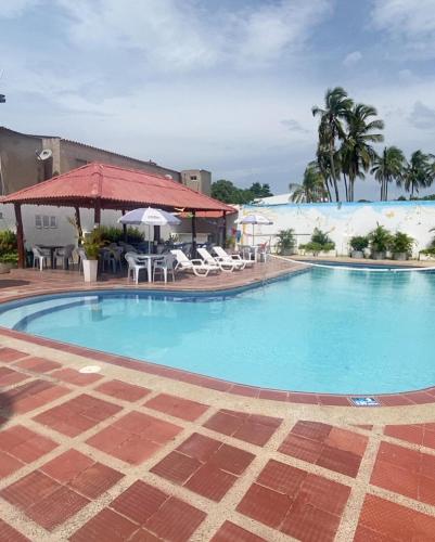 una grande piscina con sedie e ombrelloni di Hotel la Sierra Riohacha II a Ríohacha