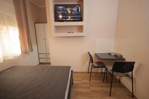 Vrnjačka Banja的住宿－Soho 1，小房间设有一张桌子和一台墙上的电视