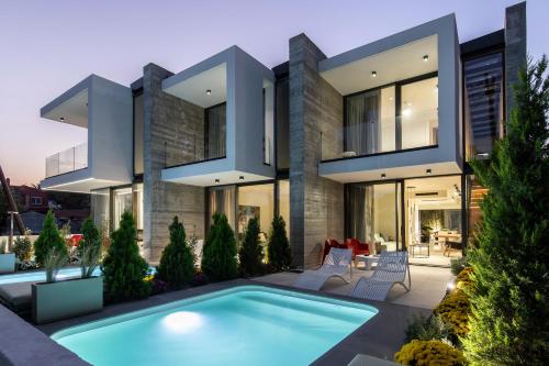 a house with a swimming pool in front of it at IKIES 3 Modern Eco-Friendly Private Seaview SIGNATURE Villas with a Pool in Volos