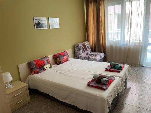 a bedroom with a bed and a chair with towels on it at Comfort Apartment in Pomorie