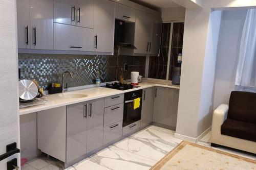 a kitchen with white cabinets and a sink at The unit beside historical elevator in Konak