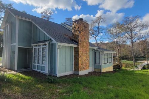 a house with a stone chimney on the side of it at GOVERNOR'S CREEK~Waterfront, King Bed w/Water View in Green Cove Springs