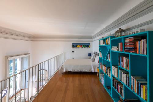 1 dormitorio con 1 cama y estantería con libros en Villa Selva Luxury Lakeview Apartment, en Ghiffa