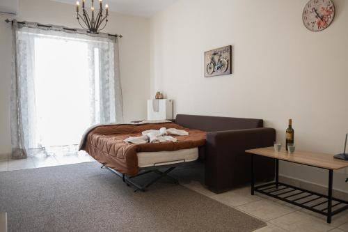 Un dormitorio con una cama y una mesa y una ventana. en Despoina's Lovely Apartment, en Nauplia