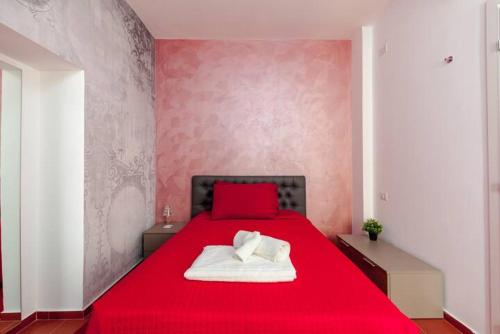 a bedroom with a red bed with two pillows on it at L'inchiostro di Dante in Macerata