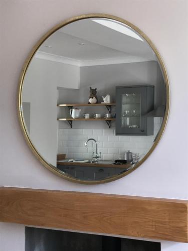 鄧布蘭的住宿－The Cottage，厨房的柜台上有一个圆镜子