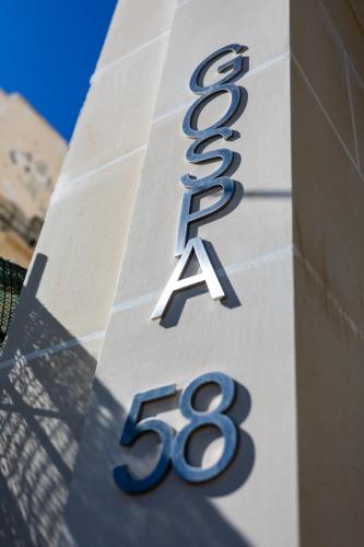 a sign on the side of a building at Gospa 58 - 1 bedroom apt in Birżebbuġa