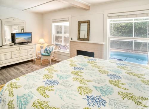a bedroom with a bed and a fireplace and a tv at Baywatch Cottage in Captiva