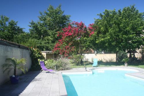 a swimming pool with two lawn chairs and a tree at Le Clos de la Salamandre in Duravel
