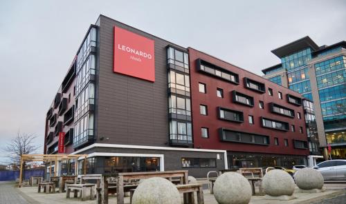 a building with a red sign on the side of it at Leonardo Hotel Newcastle Quayside in Newcastle upon Tyne
