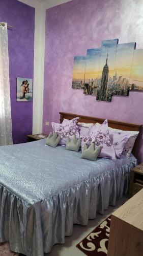 ein lila Schlafzimmer mit einem Bett mit lila Wänden in der Unterkunft Casa vacanze in Mombarcaro