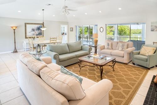 a living room with couches and a table at Baywatch Casa home in Captiva