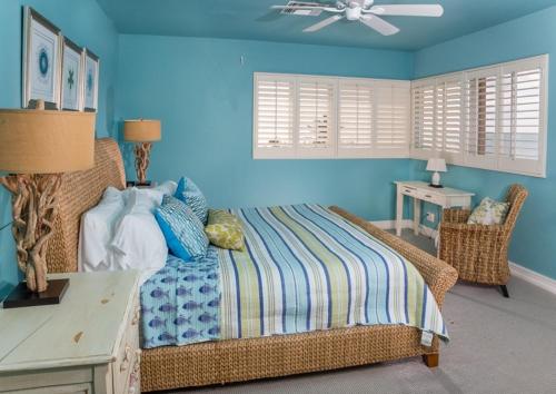 a bedroom with blue walls and a bed and a table at Conch-Captiva Beach Villas in Captiva