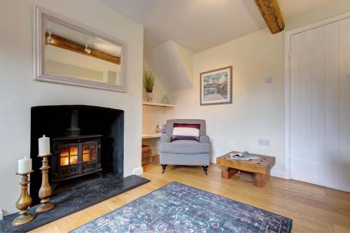 a living room with a fireplace and a chair at April Cottage in East Rudham