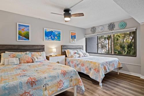 a bedroom with two beds and a window at Coastal Oasis with Pool - Walk to Coligny Beach Park in Hilton Head Island