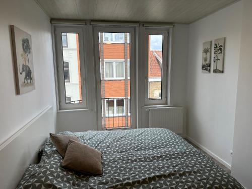 a bedroom with a bed in front of a window at "A Cabana" in De Panne in De Panne