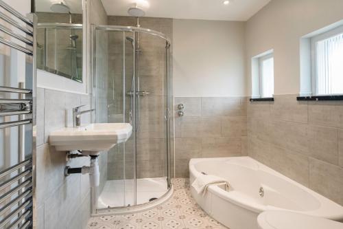 a bathroom with a shower and a sink and a bath tub at Cantley House Hotel - Wokingham in Wokingham