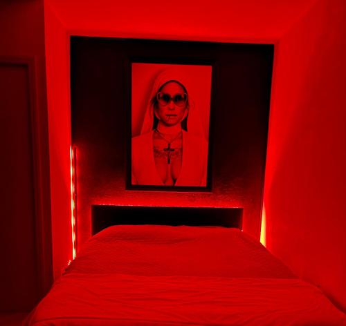 a red bedroom with a picture of a woman with sunglasses at 'Cap Confession' - Naturiste - Sea View - Beach - Parking -Air Conditionaire in Cap d'Agde