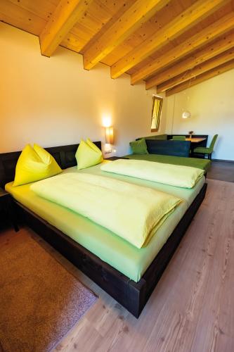 a large bed with yellow pillows in a room at Wiesenheim in Castelbello-ciardes