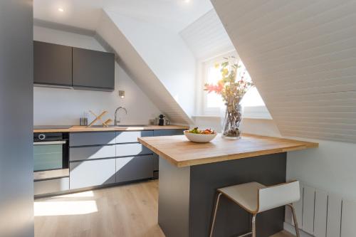- une cuisine avec un comptoir orné d'un vase de fleurs dans l'établissement Appartement neuf & tout confort - Proche Centre ville par Groom, à Lorient