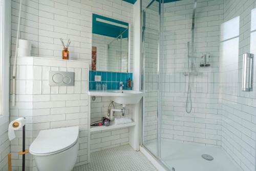 y baño con ducha, aseo y lavamanos. en Ama Hôtel, en Biarritz