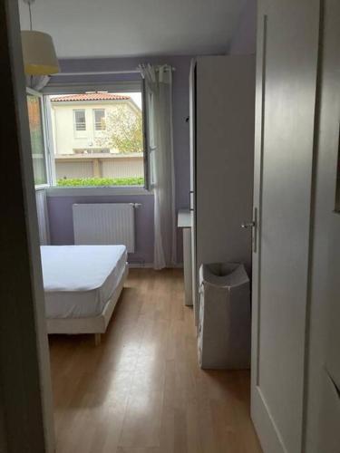 een kleine slaapkamer met een bed en een raam bij 2 pièces 38 M2 Francheville in Francheville