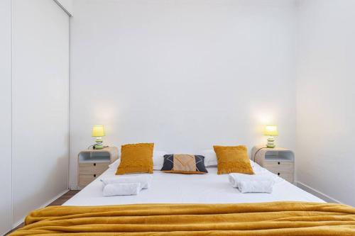 a bedroom with a large white bed with yellow pillows at MY CASA - PONCHETTES - Independent House, Promenade Des Anglais in Nice