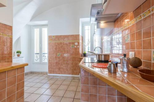 a kitchen with brown tiled walls and a counter at MY CASA - PONCHETTES - Independent House, Promenade Des Anglais in Nice