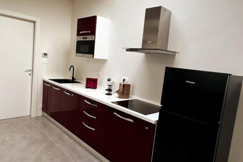 uma cozinha com um frigorífico preto e um lavatório em APPARTAMENTO LENUVOLE em Turim