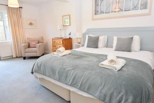 a bedroom with a large bed with towels on it at White Roses in Bembridge