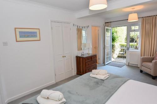 a bedroom with a bed with two towels on it at White Roses in Bembridge