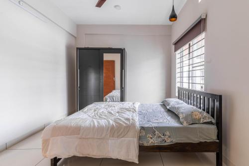 sypialnia z łóżkiem i oknem w obiekcie Amminis Mansion by Doris Homes w mieście Triśur