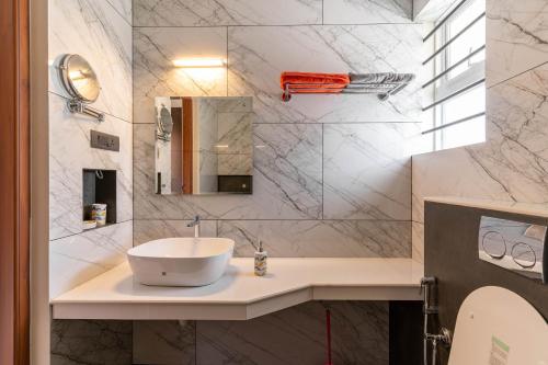 a bathroom with a sink and a mirror at Amminis Mansion by Doris Homes in Trichūr