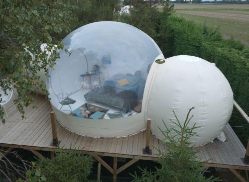 an orb and a ball on a wooden deck at Ecolieu BnBubble Drincham by BubbleTree BBT SARL in Drincham