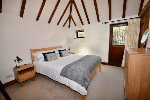 a bedroom with a large white bed and a window at The Cote is a stunning rural barn beach 3 miles in Ryde