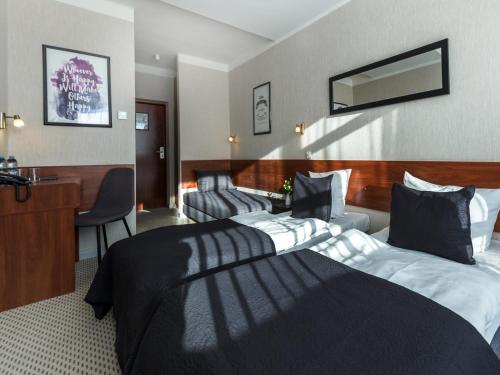 a hotel room with a bed and a desk at Diuna Beskidy Ustroń - dawny Kolejarz in Ustroń