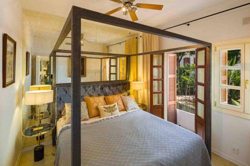 1 dormitorio con 1 cama y ventilador de techo en Luxury stay near Puente Romano, always Heated Pool 5*, en Marbella