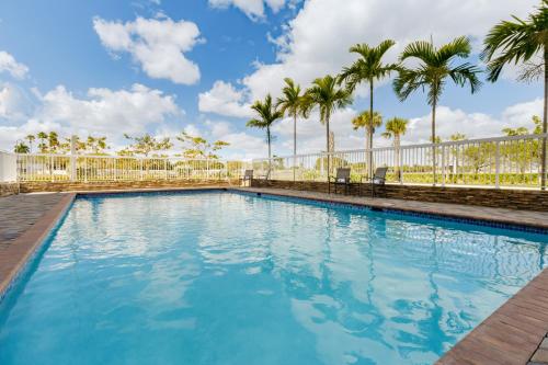 a swimming pool with palm trees in the background at Fairfield Inn & Suites Homestead Florida City in Florida City