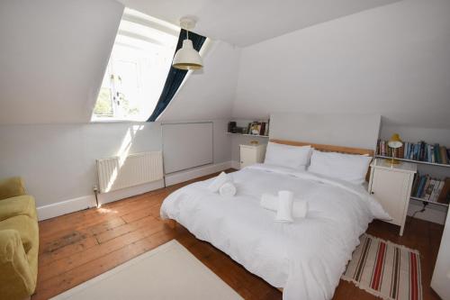 um quarto com uma cama branca com duas toalhas brancas em Arden Villa, sleeps 8, moments from the golden sandy beach of Ryde em Ryde