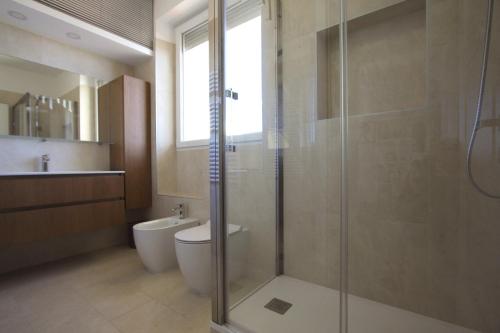 een badkamer met een toilet en een glazen douche bij Sunny Flaminio Terrace Penthouse in Rome