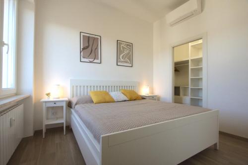een witte slaapkamer met een bed en een spiegel bij Sunny Flaminio Terrace Penthouse in Rome