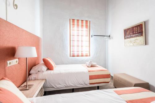 um pequeno quarto com 2 camas e um candeeiro em Apartamento Atalaya Golf I-II-III em Estepona