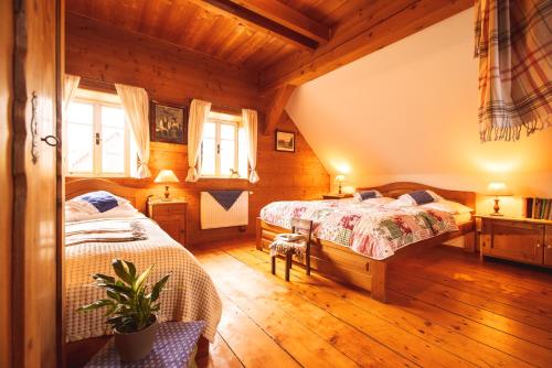 2 łóżka w pokoju z drewnianą podłogą w obiekcie Penzion Na Stodolci w mieście Chřibská