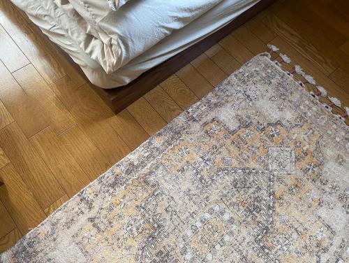 a rug with a cross on a floor with a bed at ゲストハウスよるよなか in Nagoya