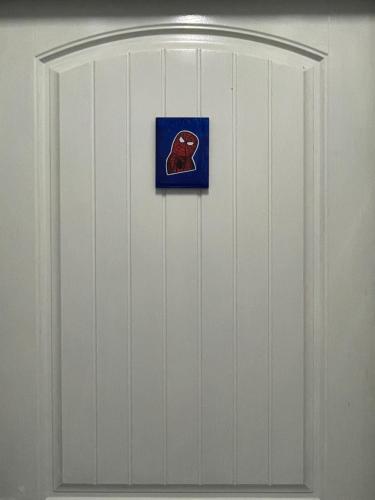 a white door with a blue sign on it at เส้นดี โฮสเทล Sendee Hostel in Phitsanulok