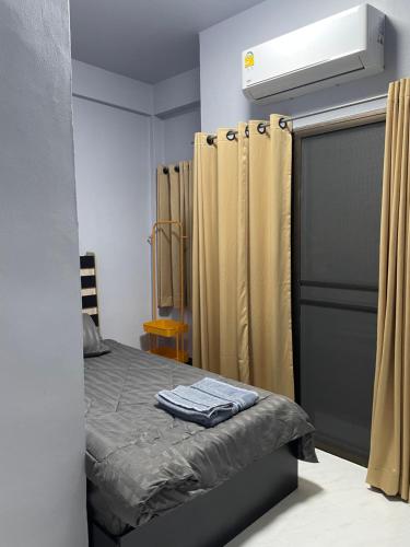 a bedroom with a bed and a closet with curtains at เส้นดี โฮสเทล Sendee Hostel in Phitsanulok