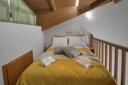 a bedroom with a large yellow bed with two pillows at Sofita Center in Heraklio