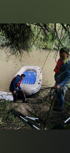 two men are working on a boat in the water at Hotel Rokas de Suesca in Suesca
