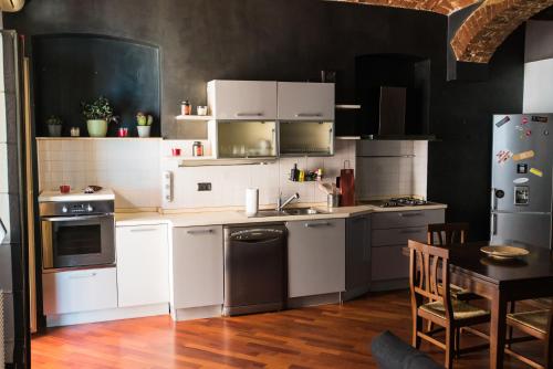una cocina con armarios blancos y una mesa con mesa en Orpheus Apartment, en Turín