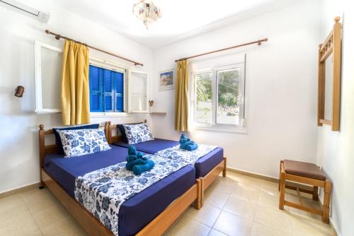 a bedroom with a bed with blue teddy bears on it at Villa Lia Panorama in Pefki